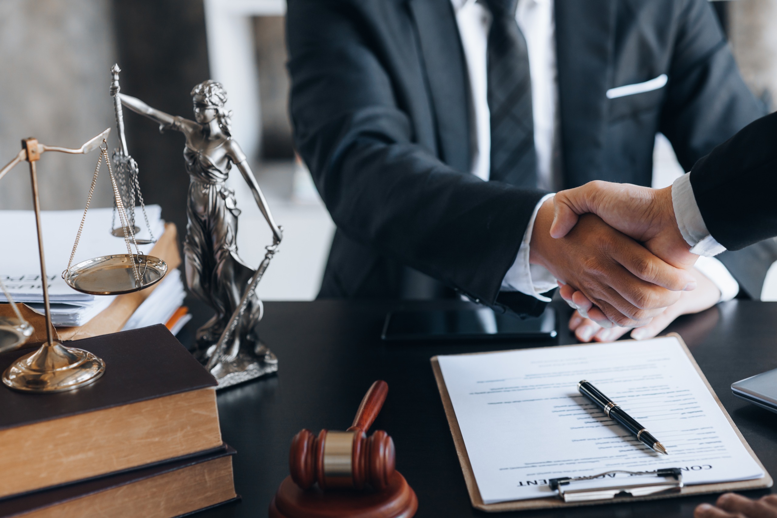 Lawyer and client shake hands, after winning a lawsuit where a l