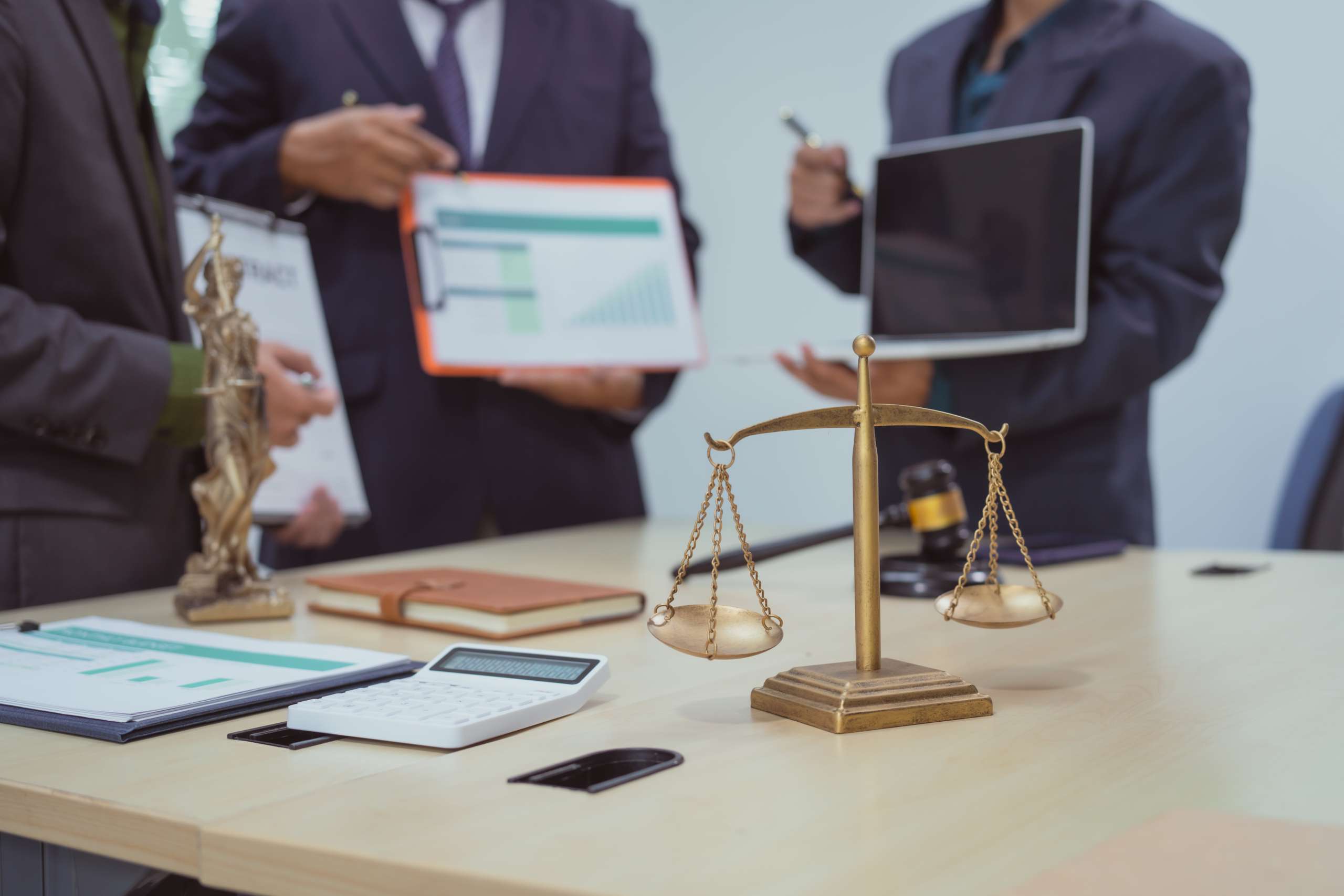 Three lawyers in a meeting at the table in an office, discussing